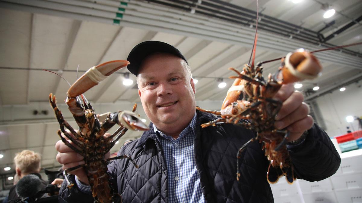 Köparen av första humrarna. Pengarna skänks till välgörenhet. (Foto: TT)