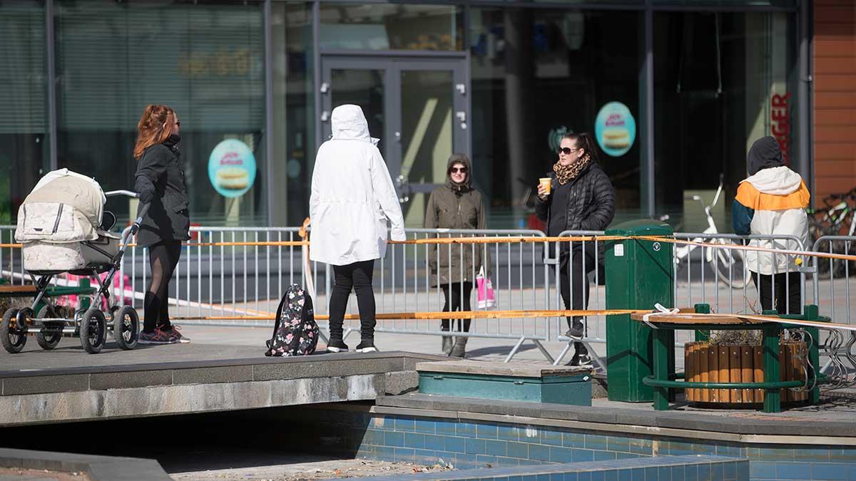 olk i Haparanda samtalar med andra i finska Torneå över ett kravallstaket, som sattes upp då Finland stängde gränsen i mitten av mars med anledning av coronapandemin. (Foto: TT)