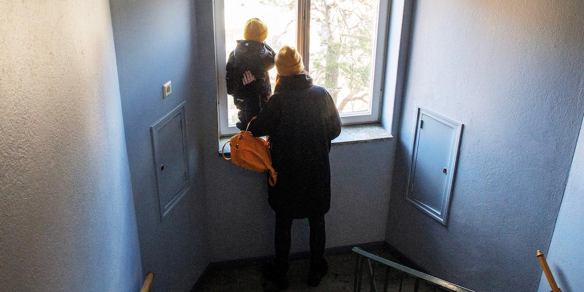 Förälder och barn tittar ut från fönster i trappuppgång. En undersökning visar att ensamstående föräldrar i stor utsträckning pensionssparar mindre, men att spara kan påverka pensionen mycket