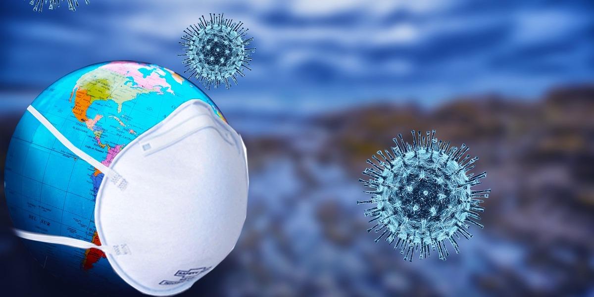 Virus och en jord med munskydd. Nya varianter av viruset som orsakar covid-19 sprider sig och kan vara mer smittsamma än tidigare virusvarianter.