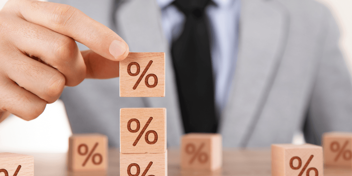 Hand håller i kub med %-tecken på.