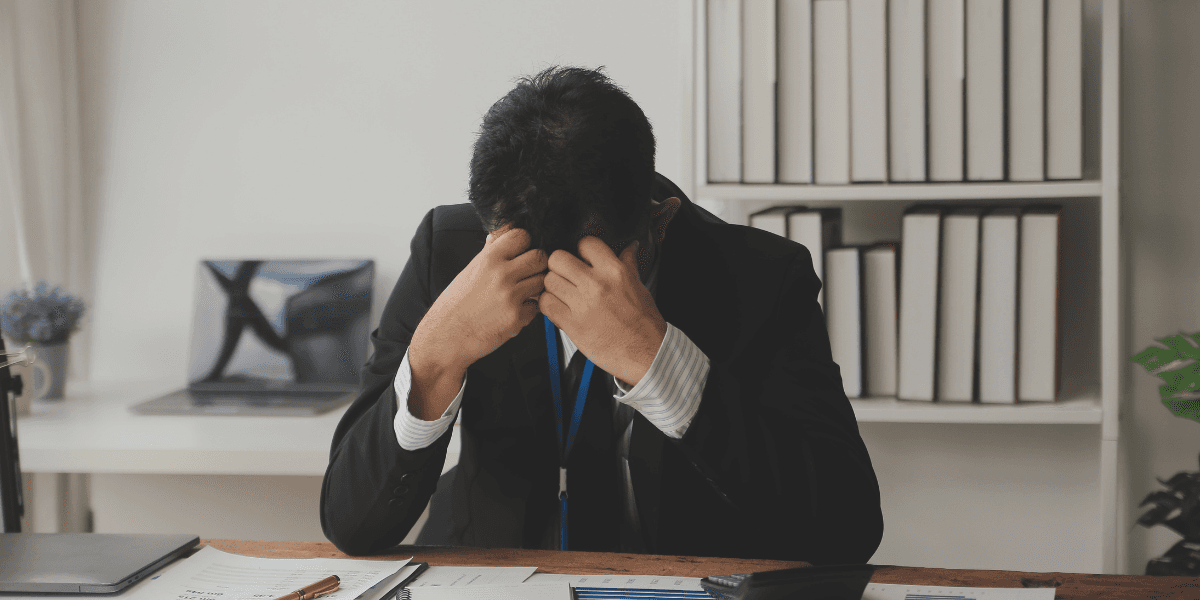 Stressad kontorsanställd på arbetsplats som påverkas av AI-omställning och minskade juniora roller.