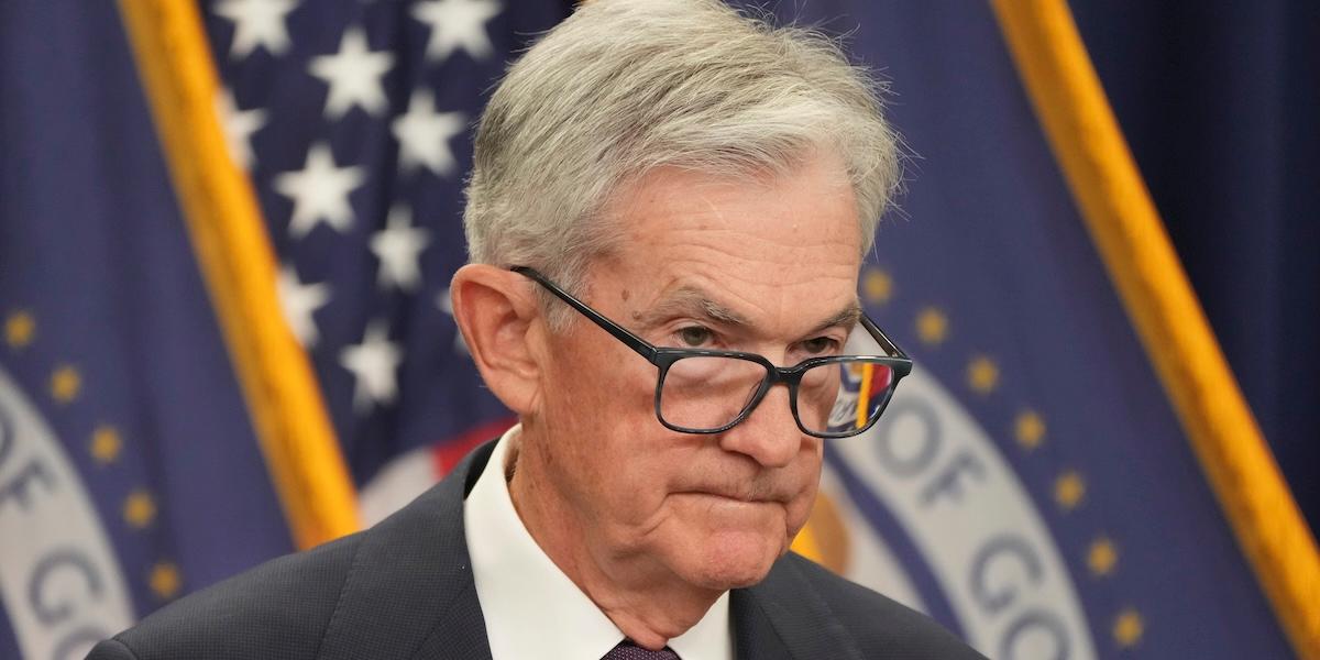 Jerome Powell vid podiet under Fed-presskonferens, med amerikansk flagga i bakgrunden.
