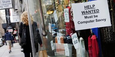 Skyltfönster i amerikansk stad med lapp om att personal sökes – "Help Wanted"