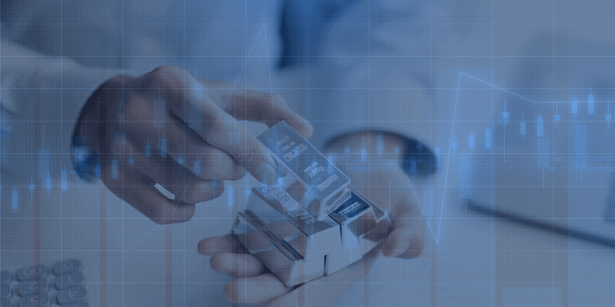 Hand som håller silvertackor med överlagrad graf – symboliserar silvrets uppgång på råvarumarknaden.